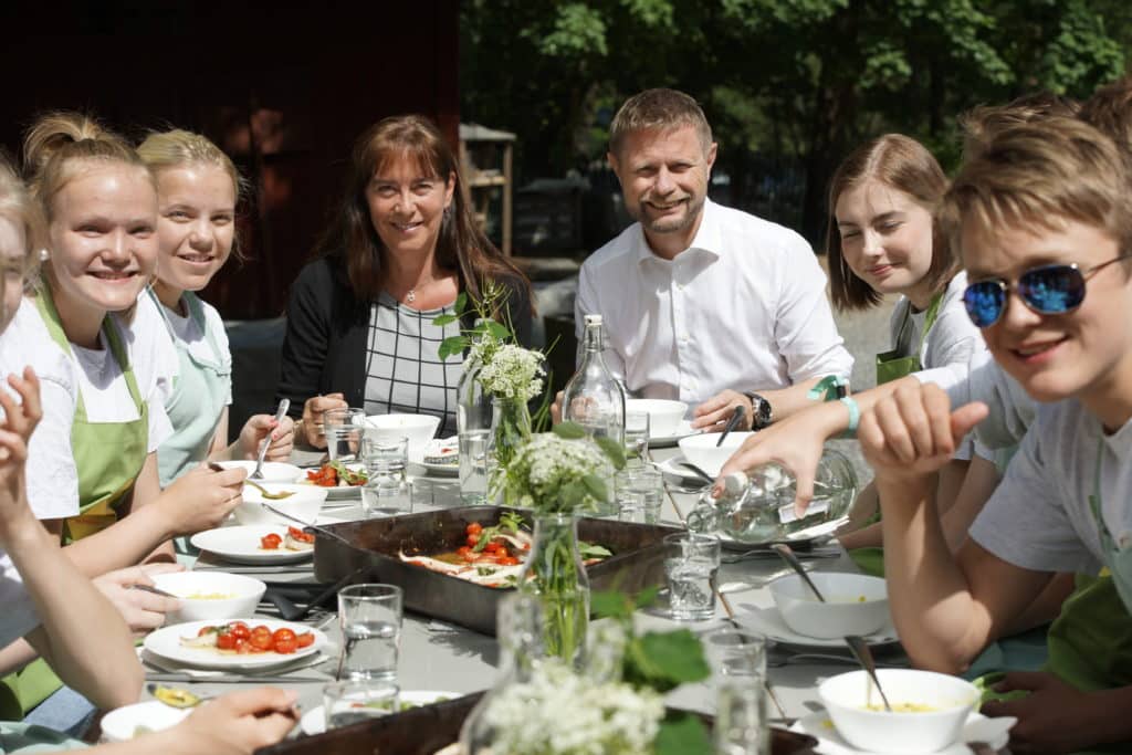 Bilde av folk rundt lunsjbord ute på Geitmyra matkultursenter