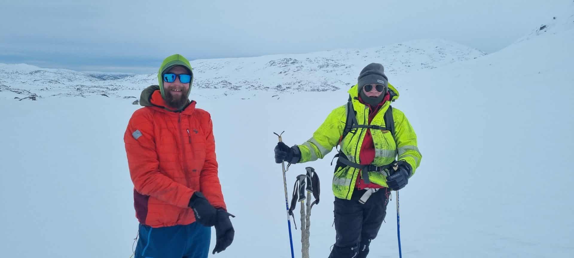 To redningsmannskaper som står på ski på fjellet